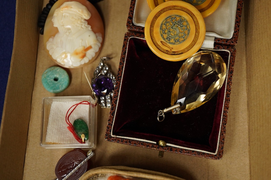 A group of jewels, comprising: three carved coral beads depicting classical women; a synthetic colour-change sapphire and paste pendant; a citrine drop pendant; a bar brooch with a scaraboid carnelian bead carved with an
